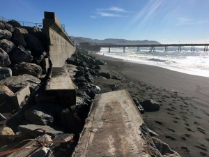 Broken seawall, with the Pacifica Pier in the distance.